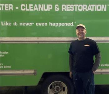Male SERVPRO employee in front of green SERVPRO truck
