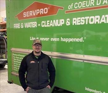 SERVPRO male employee in front of Green SERVPRO Truck