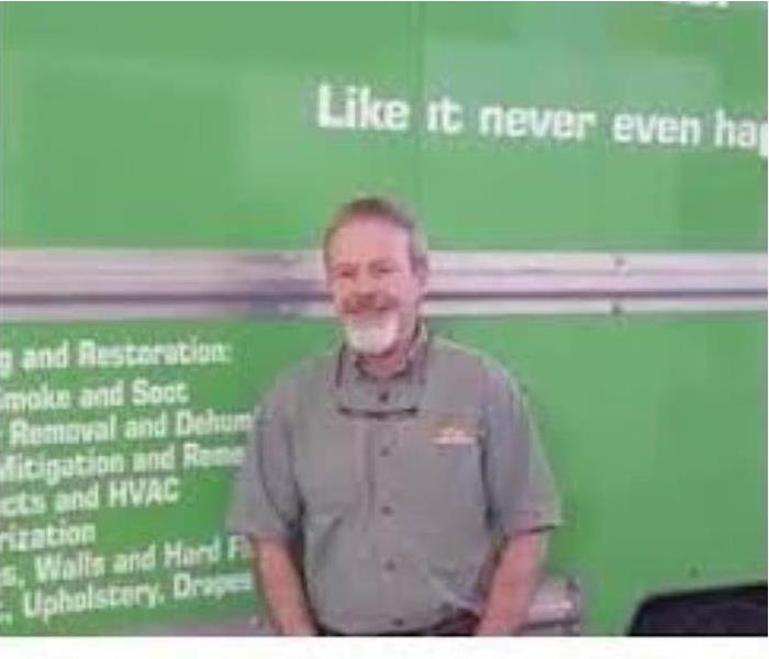 A picture of the owner Bryan Enos in front of a SERVPRO green truck