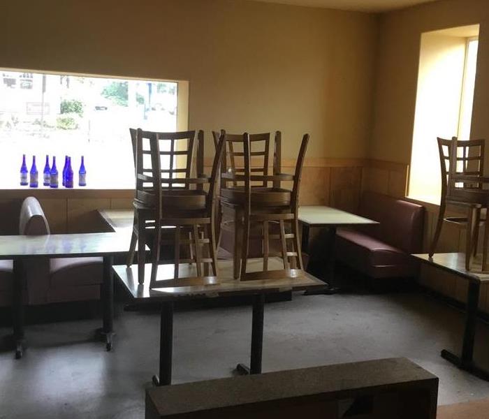 Cleaning with chairs and tables stacked for a restaurant dining area.