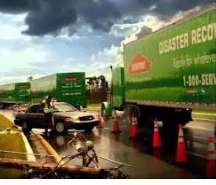 Green Servpro vehicles gathering together for a storm