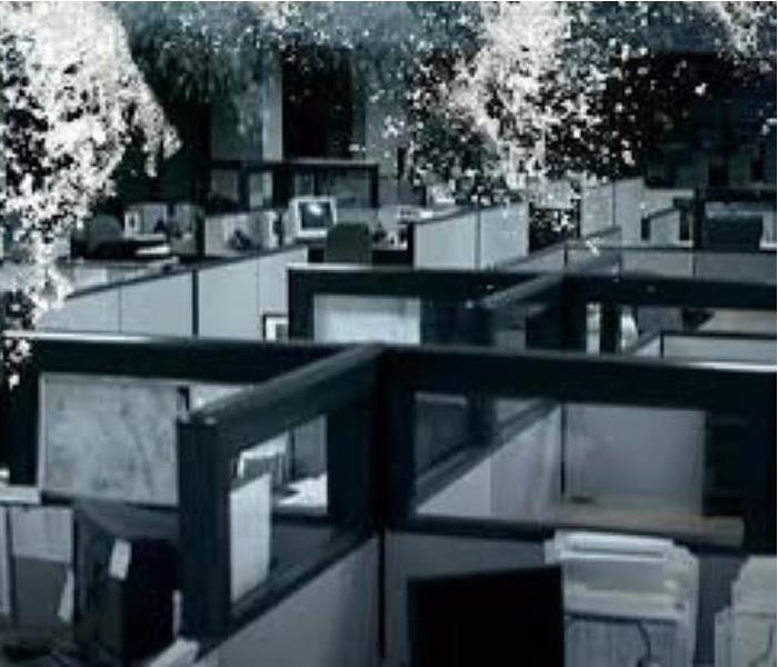 Black and White picture of office cubicles with water coming out from the ceiling 